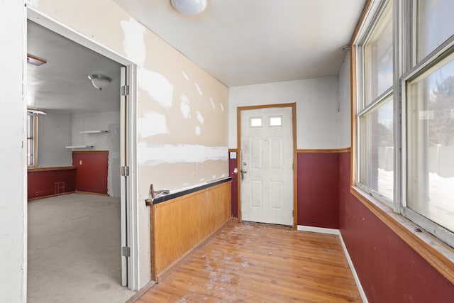 doorway to outside with wood finished floors and baseboards