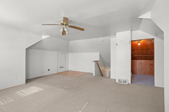 additional living space featuring lofted ceiling, carpet, visible vents, and a ceiling fan