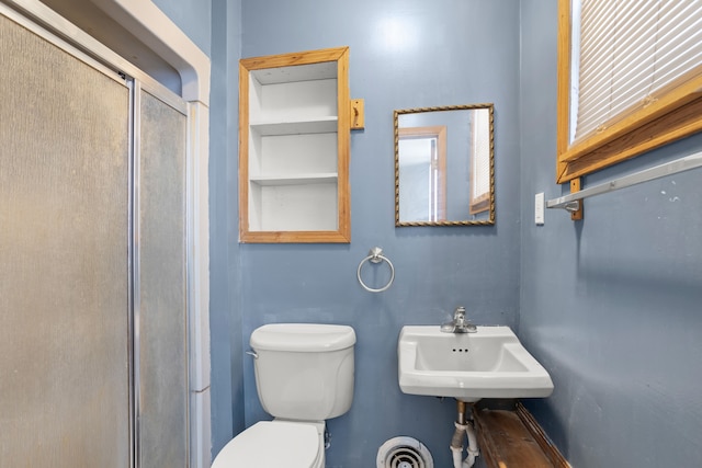 full bathroom featuring a stall shower, a sink, and toilet