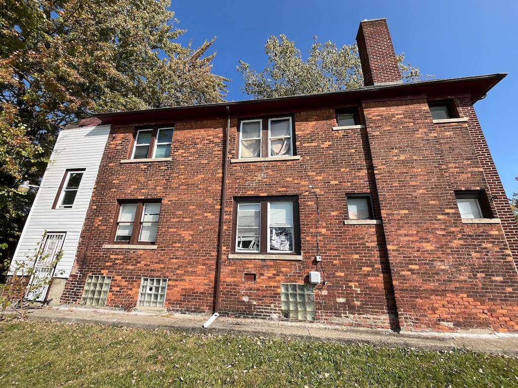 view of property exterior with brick siding and a chimney