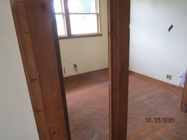 empty room featuring dark wood finished floors and baseboards