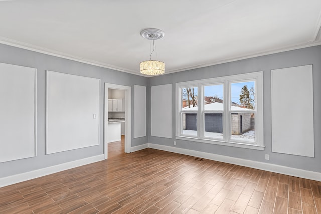 interior space with crown molding, baseboards, and wood finished floors