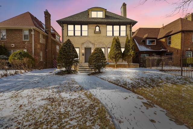 view of front of home featuring brick siding and fence