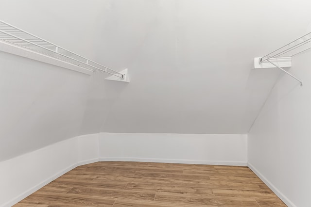 walk in closet featuring lofted ceiling and wood finished floors