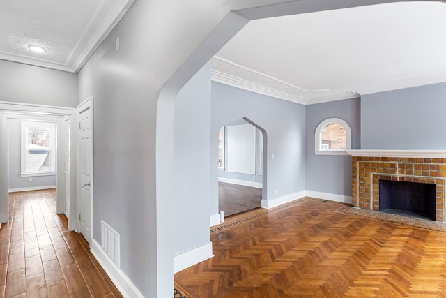 hall featuring arched walkways, visible vents, crown molding, and baseboards