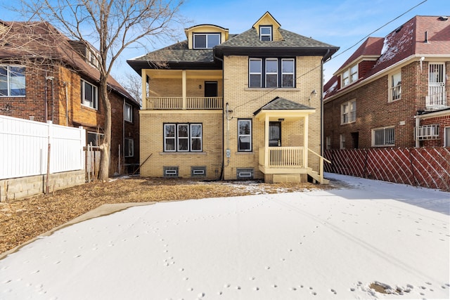 view of front of house featuring fence private yard, roof with shingles, and brick siding