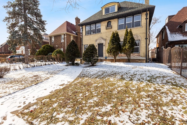 view of front of home with brick siding, fence, and a residential view