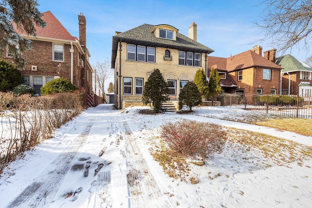 view of front of property featuring brick siding and fence