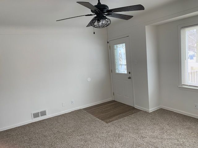 carpeted entryway featuring a ceiling fan, visible vents, and baseboards