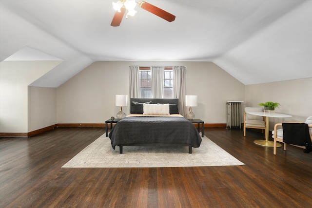 bedroom with dark wood finished floors, lofted ceiling, radiator, a ceiling fan, and baseboards