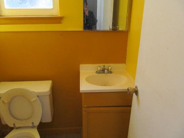 half bathroom featuring toilet and vanity