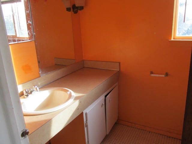 bathroom featuring tile patterned flooring, baseboards, and vanity