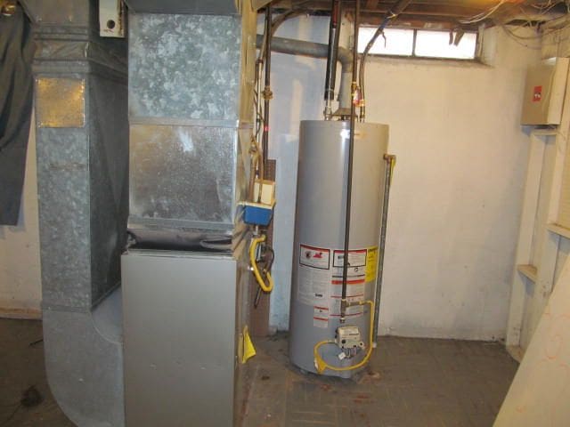 utility room featuring water heater and heating unit