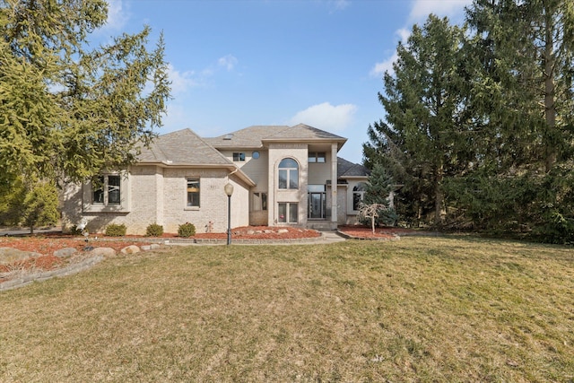 view of front facade with brick siding and a front yard