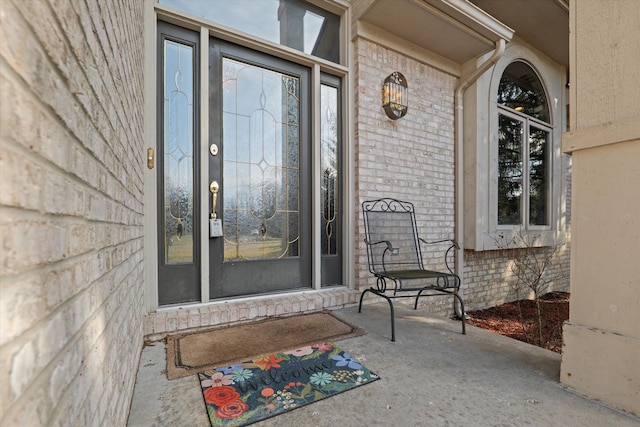 doorway to property featuring brick siding