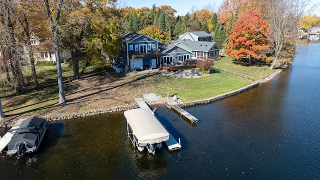 exterior space with fence, a lawn, a forest view, and a water view