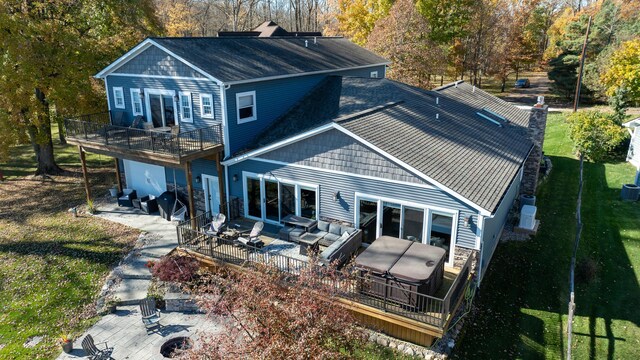 back of property featuring a chimney, a yard, a wooden deck, an outdoor living space with a fire pit, and roof with shingles