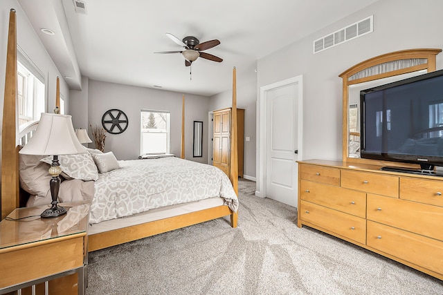 bedroom with ceiling fan, light carpet, visible vents, and baseboards