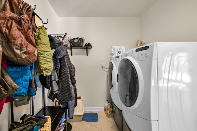 laundry room featuring laundry area, light tile patterned floors, baseboards, and washer and clothes dryer