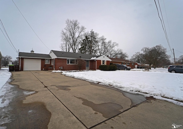 single story home featuring a garage, concrete driveway, and brick siding