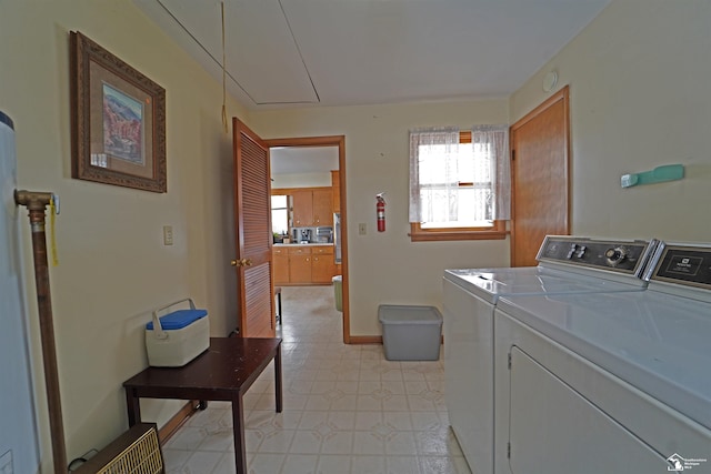 washroom featuring laundry area, independent washer and dryer, attic access, and baseboards