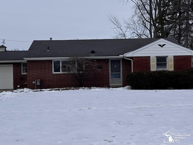 single story home featuring an attached garage and brick siding