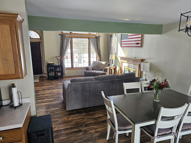 dining space featuring dark wood-type flooring and a fireplace