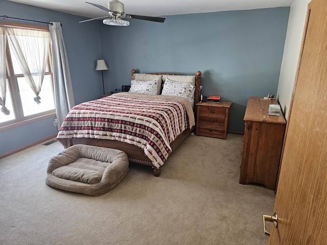 bedroom featuring visible vents, baseboards, a ceiling fan, and light colored carpet