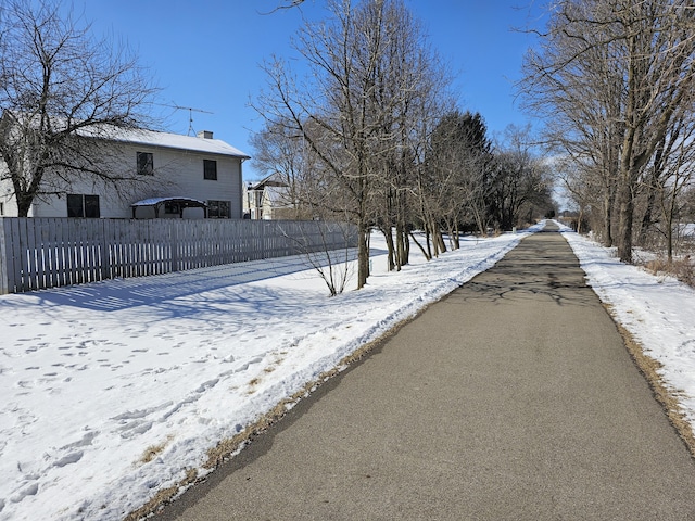 yard covered in snow featuring fence