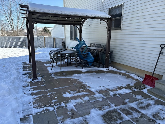 snow covered patio featuring fence and a gazebo