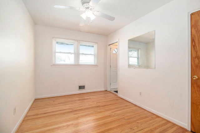 spare room featuring light wood-style floors, baseboards, visible vents, and ceiling fan