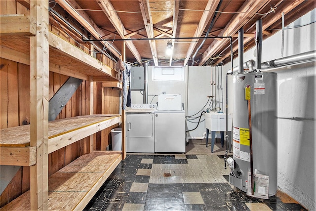 basement with water heater, washing machine and dryer, and tile patterned floors