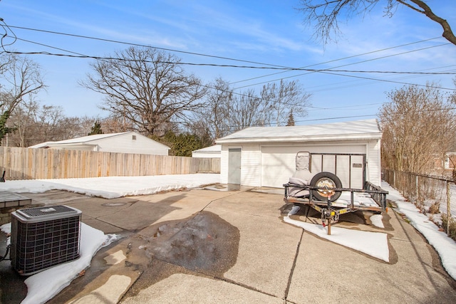 view of patio / terrace with central AC unit, an outdoor structure, a fenced backyard, and a detached garage