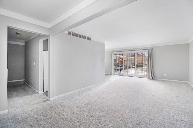 carpeted spare room featuring baseboards, visible vents, and ornamental molding