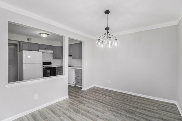 kitchen with visible vents, gray cabinets, dark wood-style floors, white appliances, and baseboards