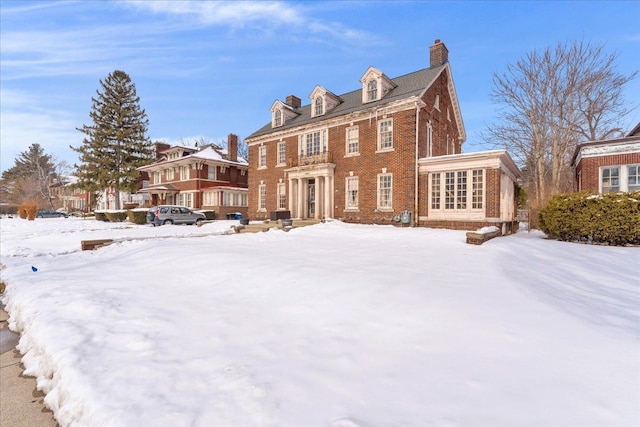 colonial home with brick siding and a chimney