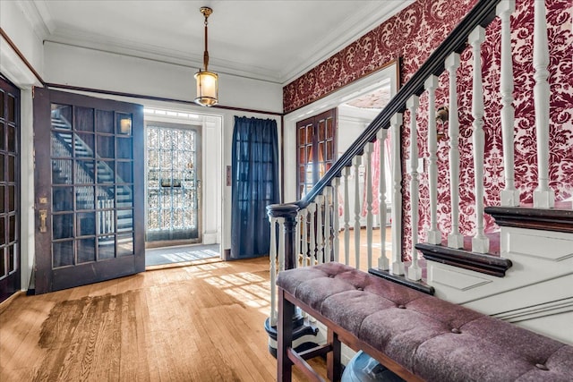 entryway with stairs, ornamental molding, and wood finished floors