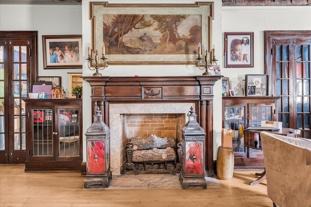 interior space with light wood-type flooring, a premium fireplace, and crown molding