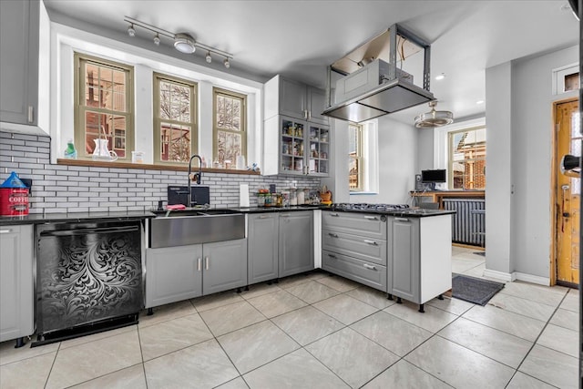 kitchen featuring dishwasher, tasteful backsplash, a sink, and gray cabinetry