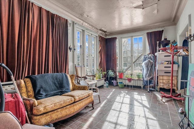 living area with a textured ceiling and ornamental molding