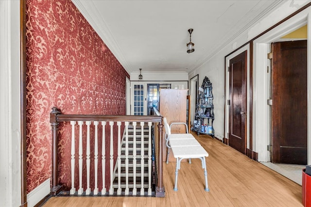 hall featuring ornamental molding, wood finished floors, baseboards, and wallpapered walls