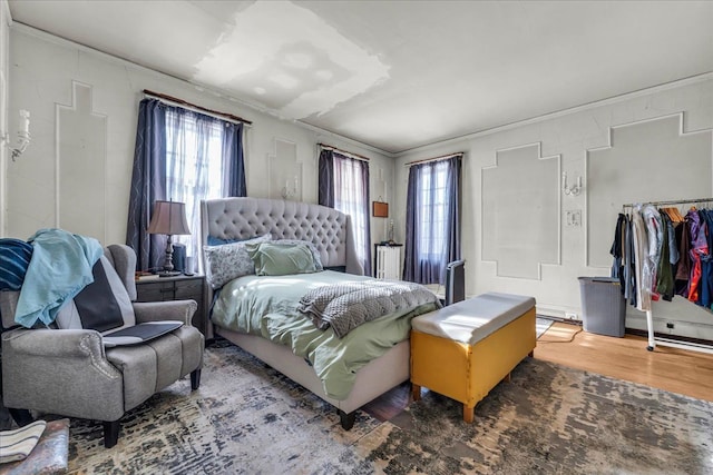 bedroom with crown molding and wood finished floors