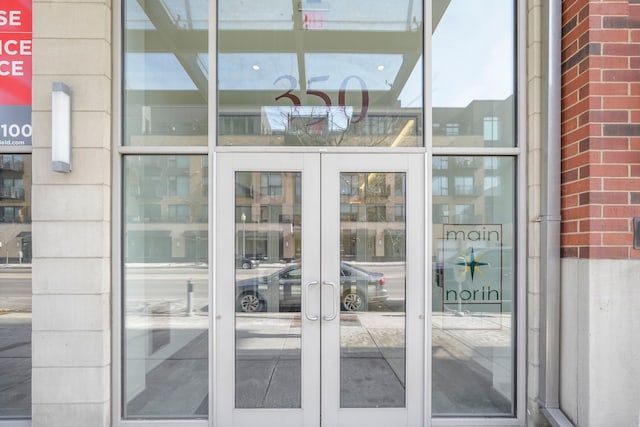 entrance to property featuring french doors and brick siding