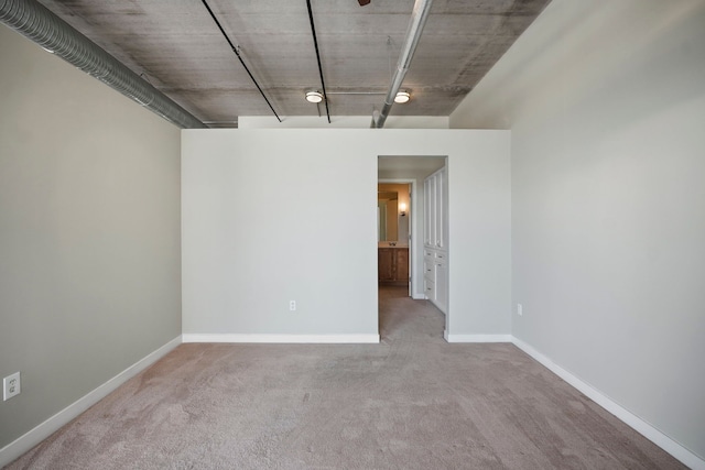 carpeted empty room featuring baseboards