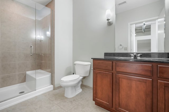 bathroom featuring toilet, vanity, visible vents, a shower stall, and tile patterned floors