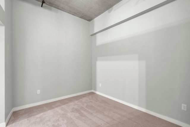 unfurnished room with light carpet and baseboards