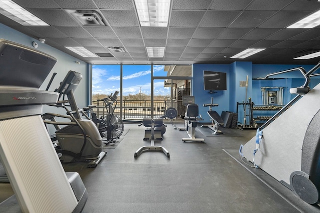 gym with expansive windows, a drop ceiling, and visible vents