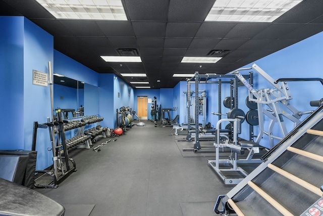 exercise room with visible vents and a paneled ceiling