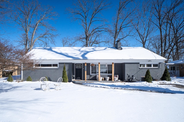 single story home featuring brick siding and a chimney