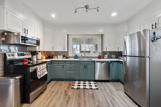 kitchen with stainless steel appliances, light countertops, and white cabinetry